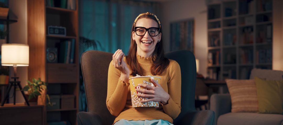 Expressive women with glasses eating popcorn