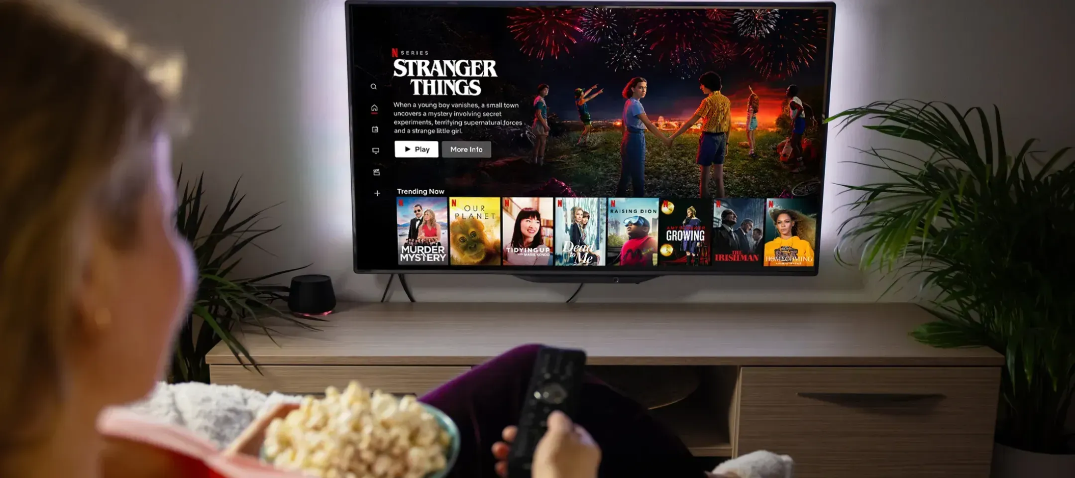 WTC Communications Kingston - Person enjoying a movie night at home, streaming Netflix on a smart TV with high-speed internet.