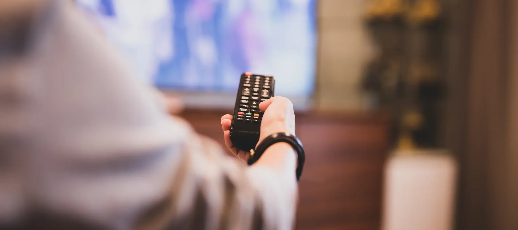 Relaxed person using TV remote watching WTC TV live broadcast